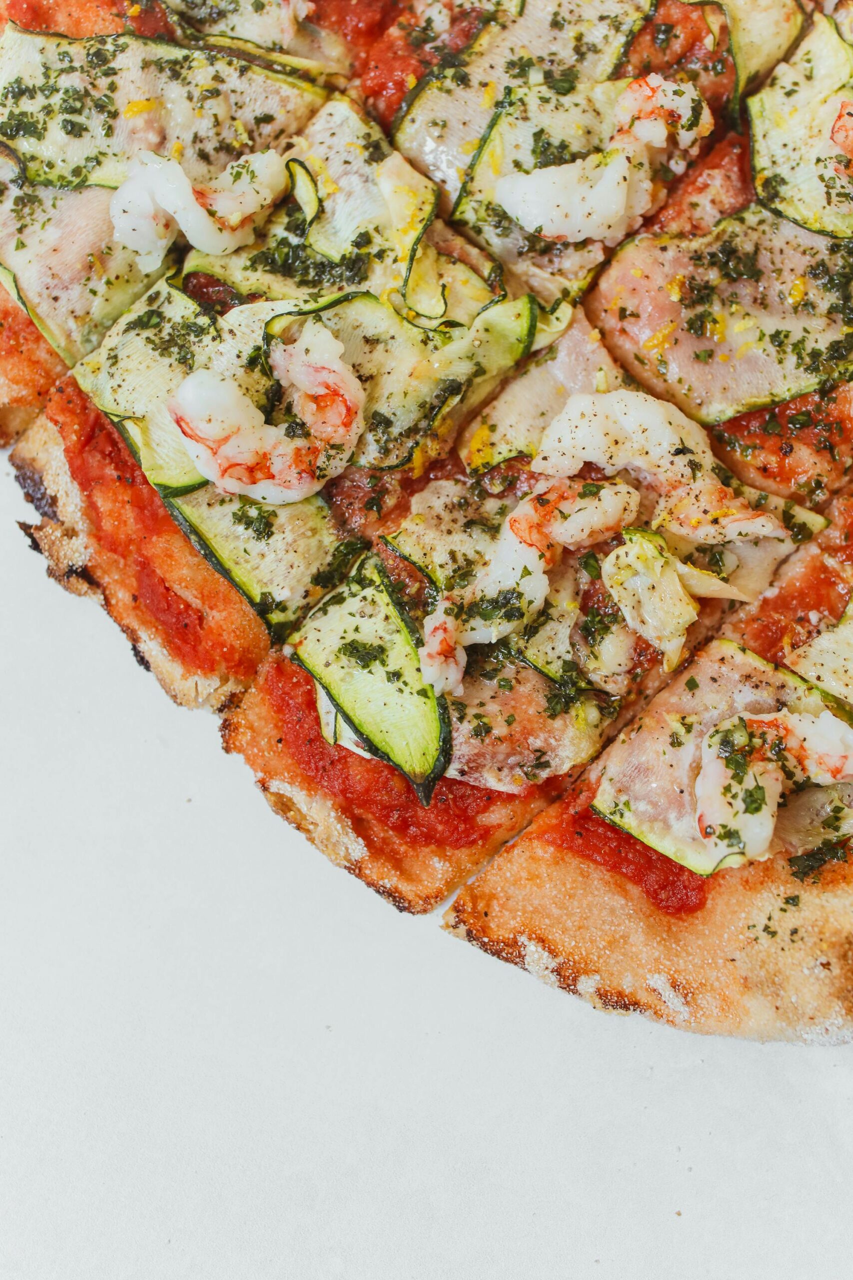 Our Menu A delectable Italian seafood pizza topped with shrimp and zucchini slices, perfect for gourmet dining.